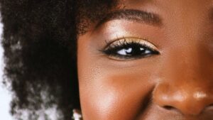 Vibrant portrait of a smiling woman with natural hair and radiant features.